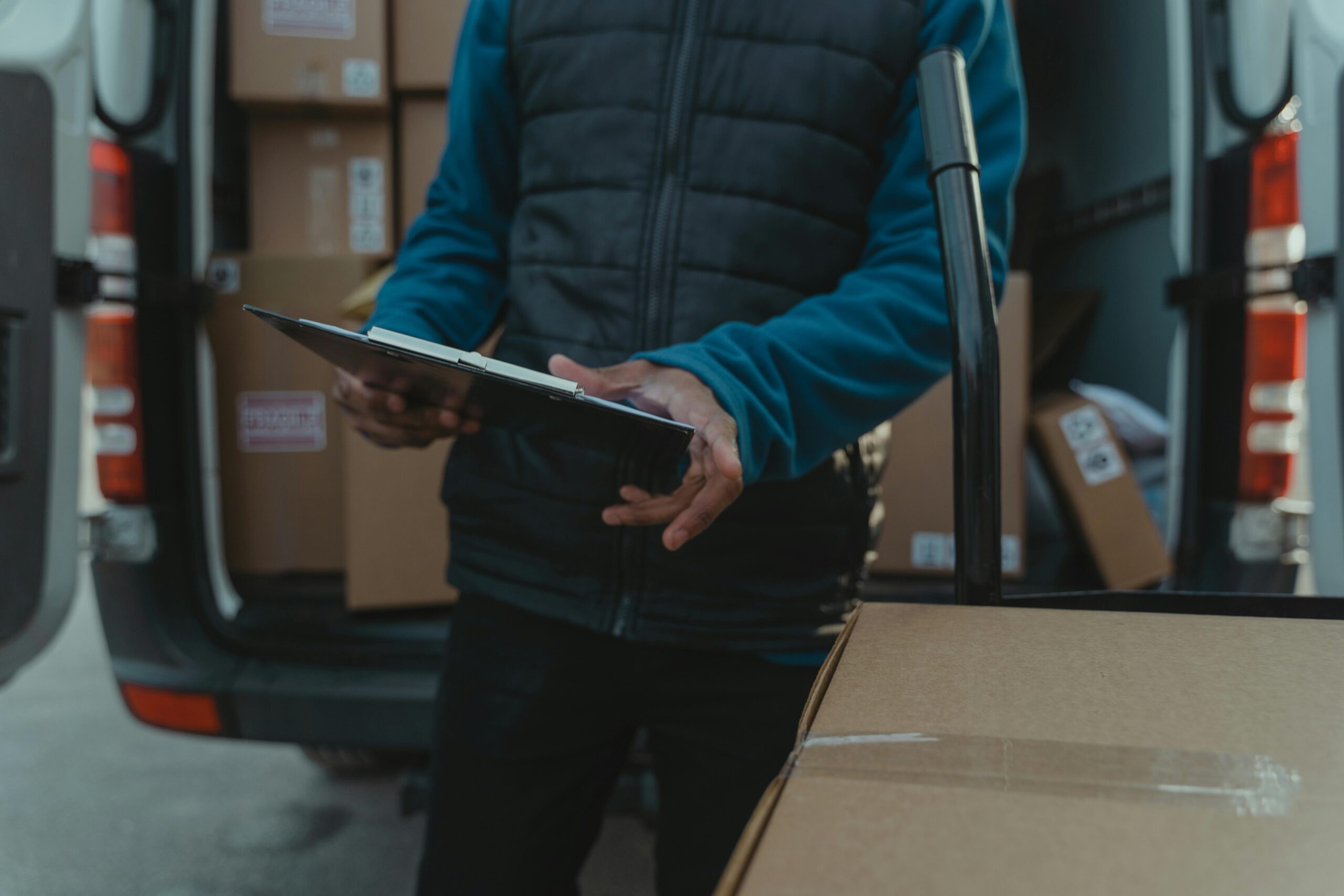 Professional medical courier driver loading secure medical supplies into a delivery van in the UK